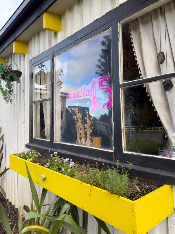 Studio 15 neon window signage with flower box at Waipapa salon